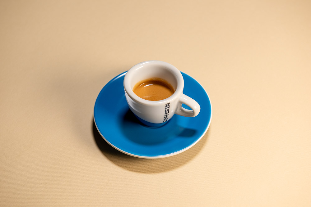 Čerstvé espresso s bohatou cremou v modrém šálku Coffeein